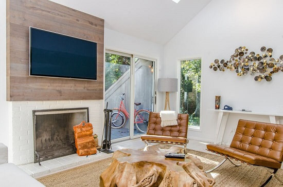Wall mounted television above a fireplace in living room.