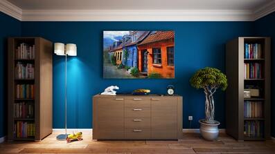 Blue room with wall mounted TV over chest of drawers.