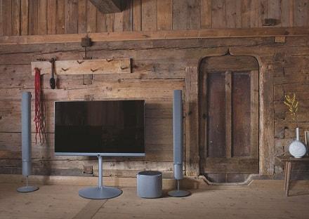 TV on stand with matching surround sound speakers in a barn.